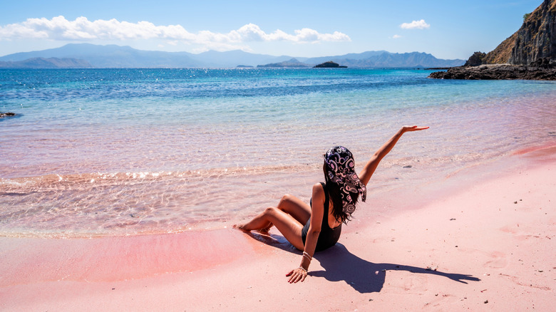 woman laying on pink beach