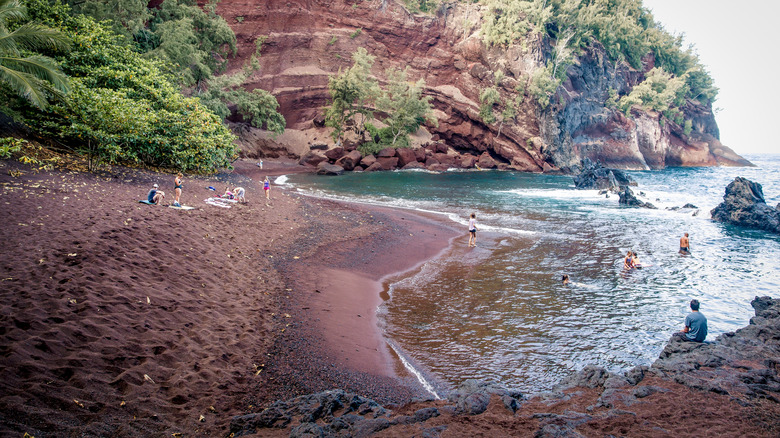 people lounging on red sand