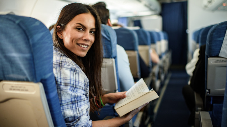 Woman on plane with book