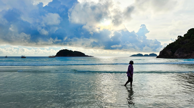 A woman wets her feet on Pulau Redang.