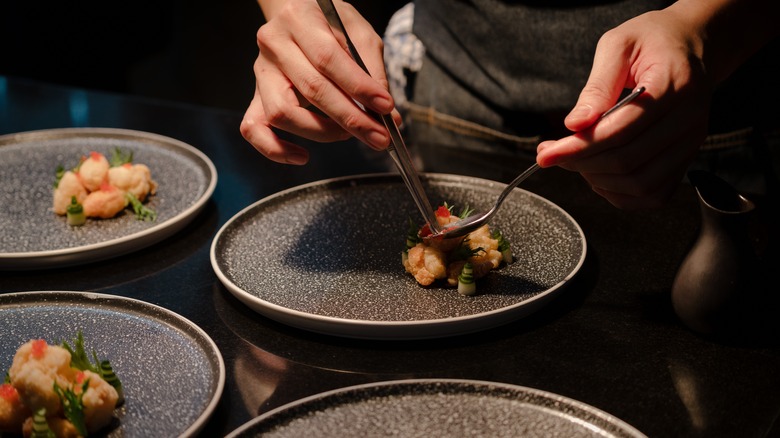 Hands preparing a plate of food