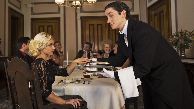 Woman taking knife from a server