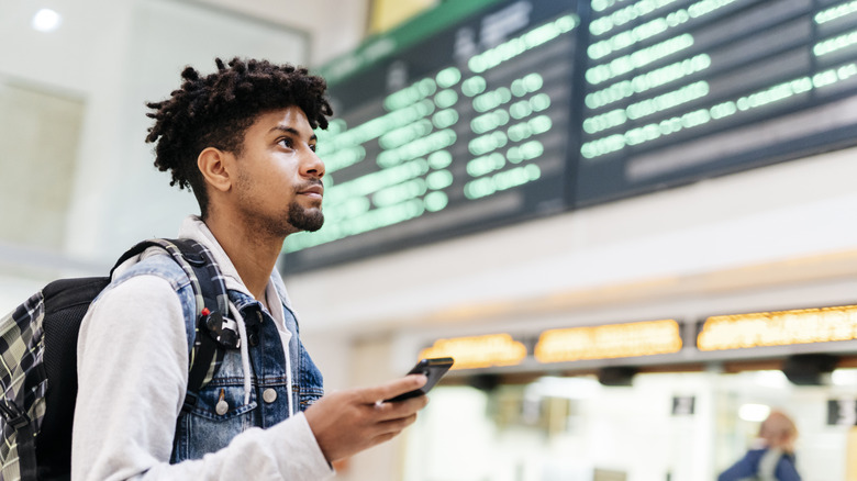 Man using his smartphone at an airport