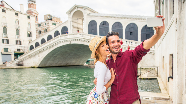 Couple taking selfie by Rialto bridge