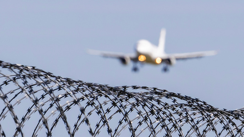 Plane landing near barbwire fence