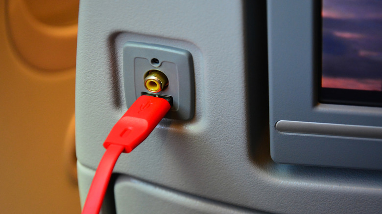 A phone charger cable in an airplane port