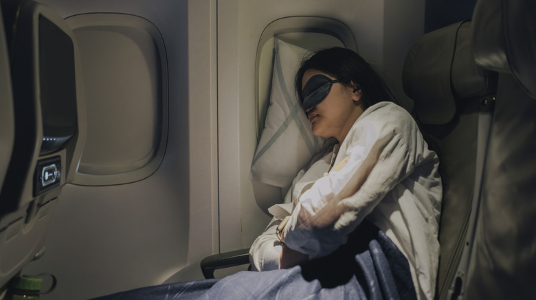 Woman wearing sleep mask on airplane