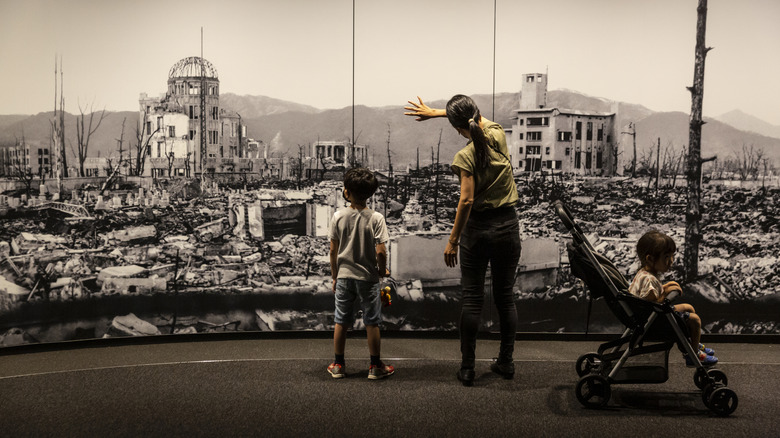 Visitors looking at a photograph of the aftermath of Hiroshima at the Hiroshima Peace Memorial Museum, Japan.