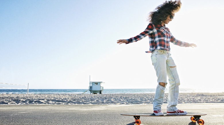 Happy skater on a skateboard on the beach