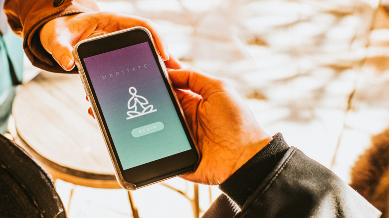 Two people holding phone showing a meditation app