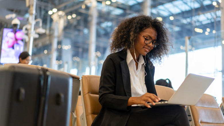 Woman on laptop at airport