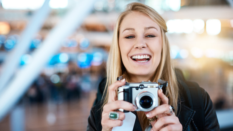 Woman taking photos at airport