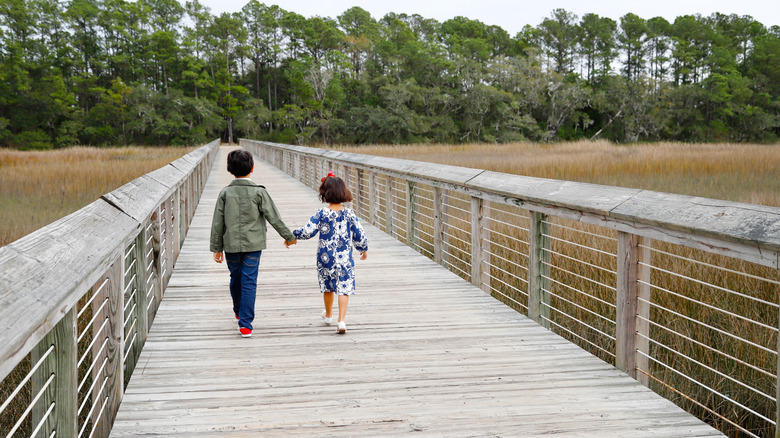 Two children walk on pier