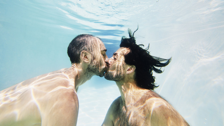 two men kissing underwater