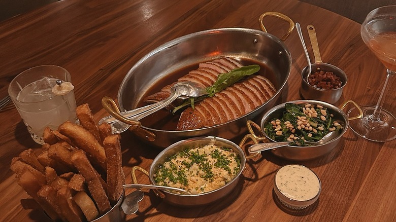 A meat dish with fries and sides at Francie in Brooklyn, New York