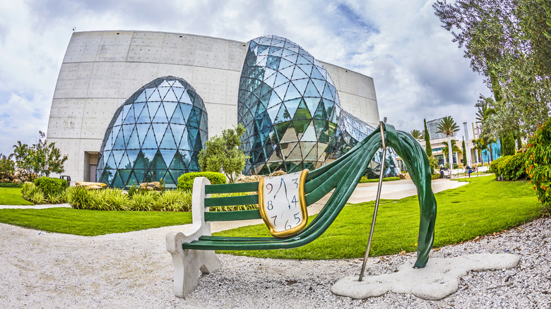 A Dalí-esque bench sits outside a funky-looking museum