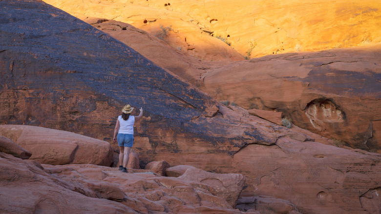 Woman examining petroglyphs