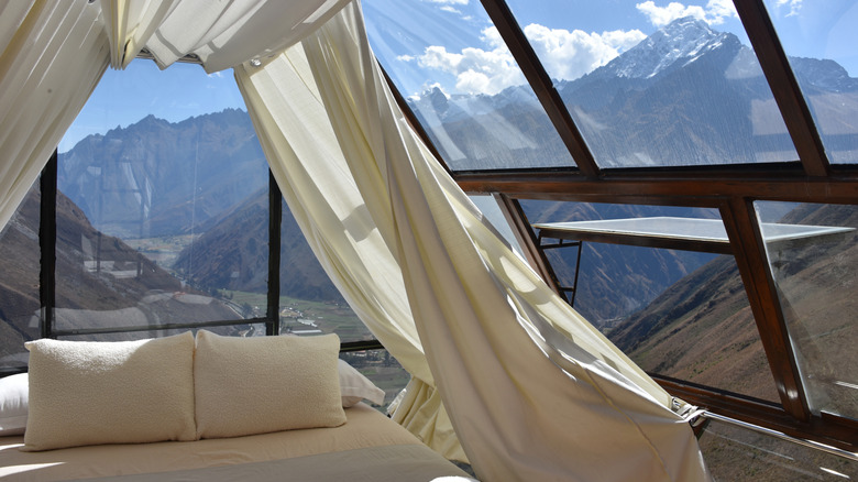 Luxury sky capsule hotel on a cliffside in Peru, with a view of mountains