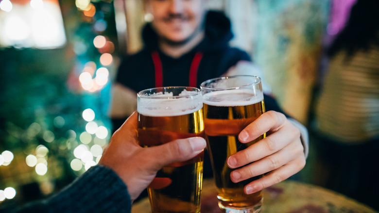 Two people clinking beer glasses