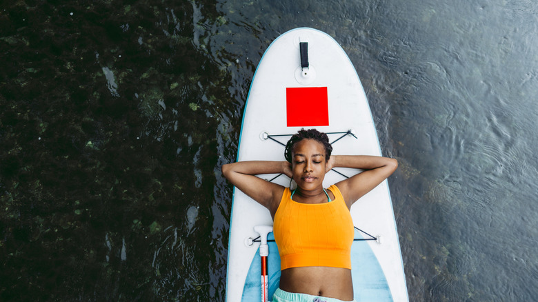 Woman lying on a stand up paddleboard