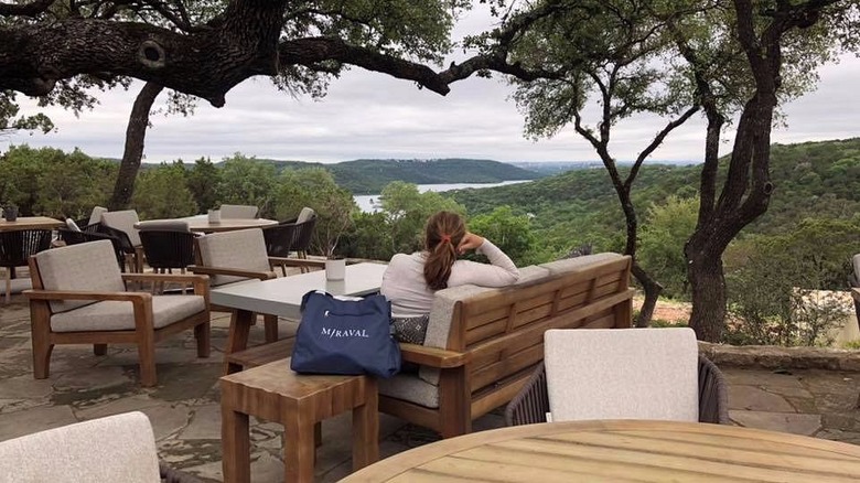 A woman sitting on a patio looking out over a stunning view