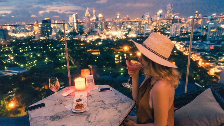 woman drinking cocktail on rooftop