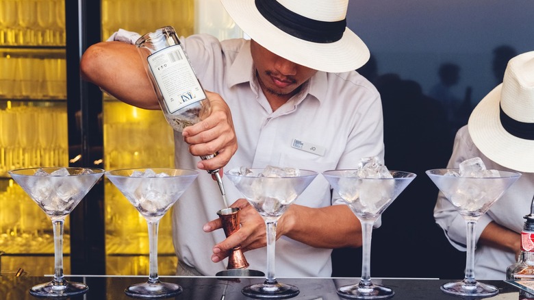 mixologist filling martini glasses