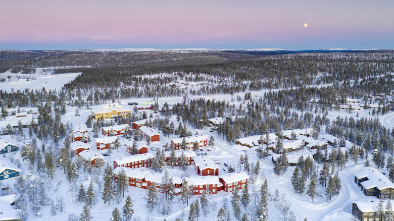 Red buildings surrounded by snow-covered terrain at dusk