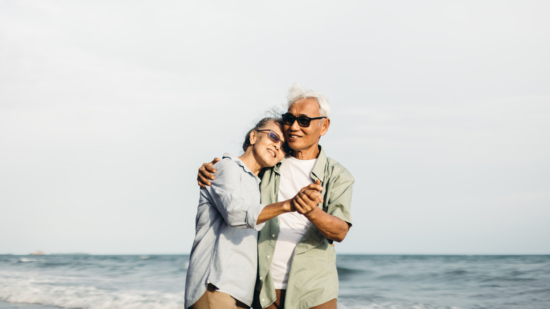 Old couple standing near the sea