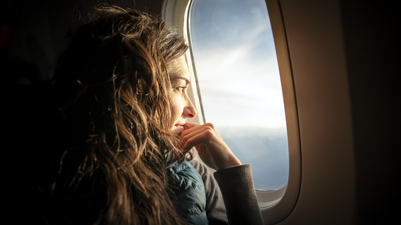 Woman looking out window of plane