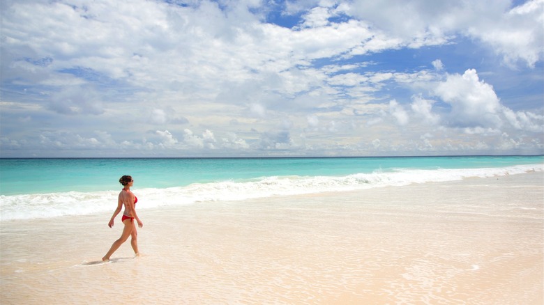 Woman walking along beach in Barbados