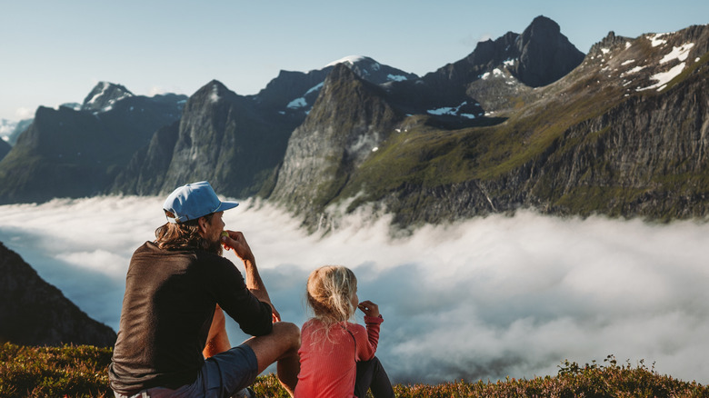 Father and daughter enjoying view of Norwegian mountains