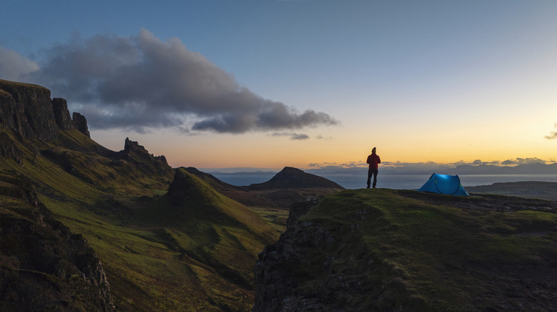 Man standing beside tent by the Quiraing Walk