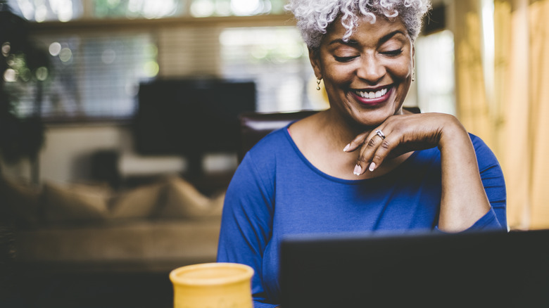 Woman smiling while using computer