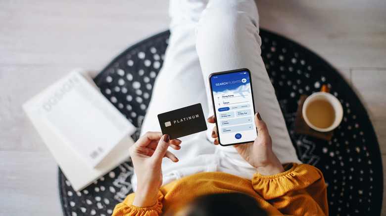 Overhead view of woman booking flight with credit card