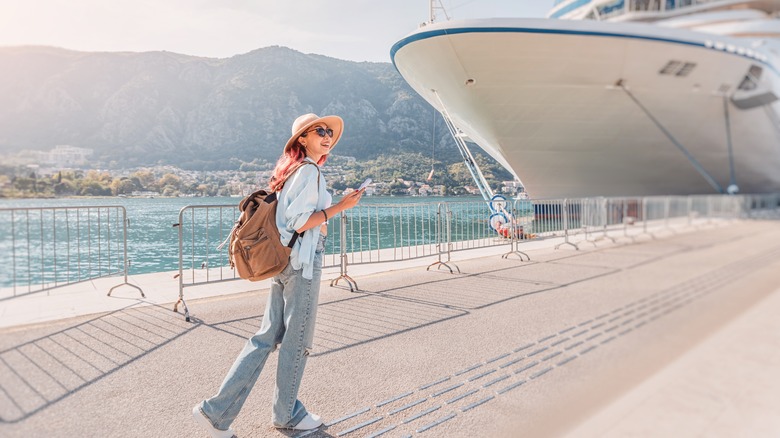 Woman wearing a backpack about to get on a cruise ship