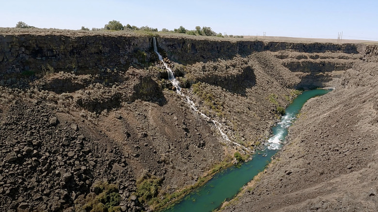 Waterfall into a small blue river at the Malad Gorge in Idaho