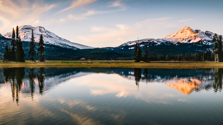 Two mountain peaks in Oregon reflected in the still water of a lake