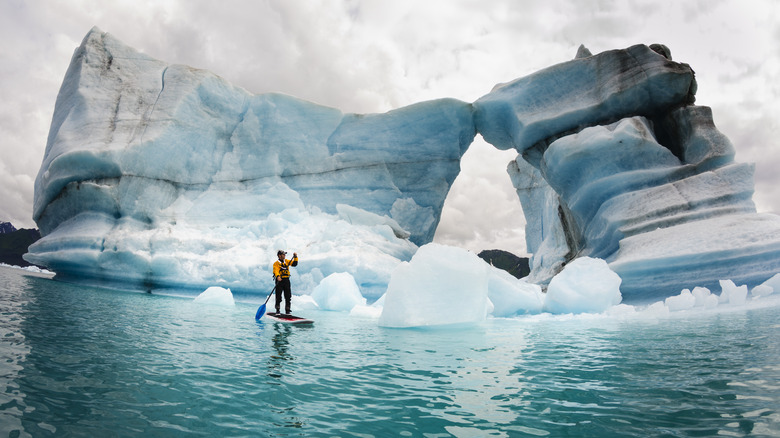 Paddleboard next to iceberg