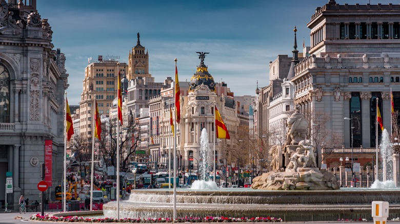 fountain with Spanish flags and buildings in Madrid