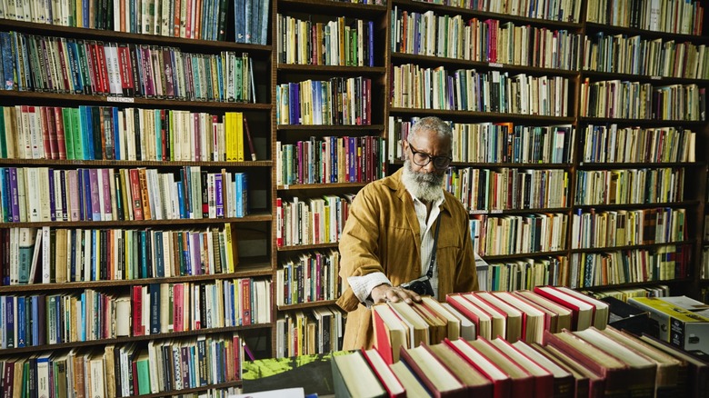 Bearded man browsing books in a crowded bookstore