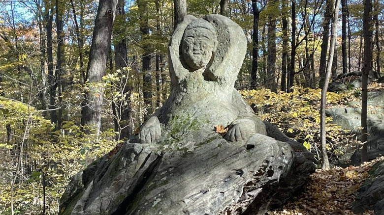 Eroded stone sphinx in forest