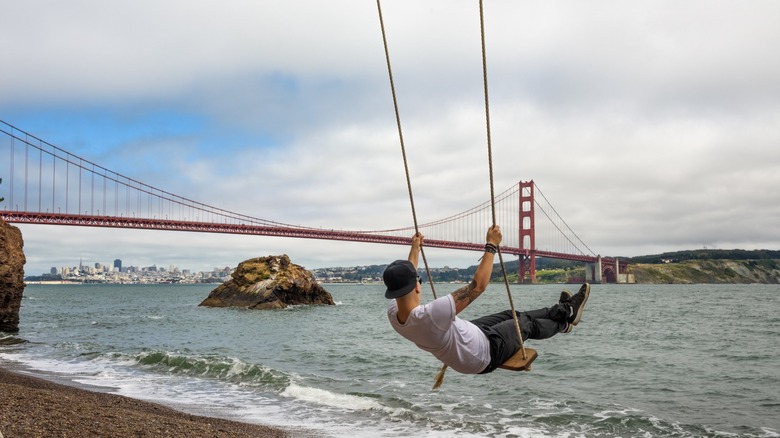 A man swinging in front of the Golden Gate Bridge