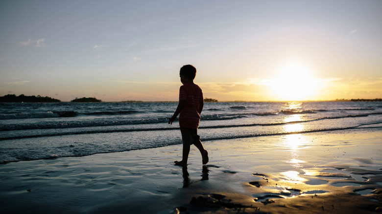 Silhouette of a child walking on Fripp Island beach at sunset