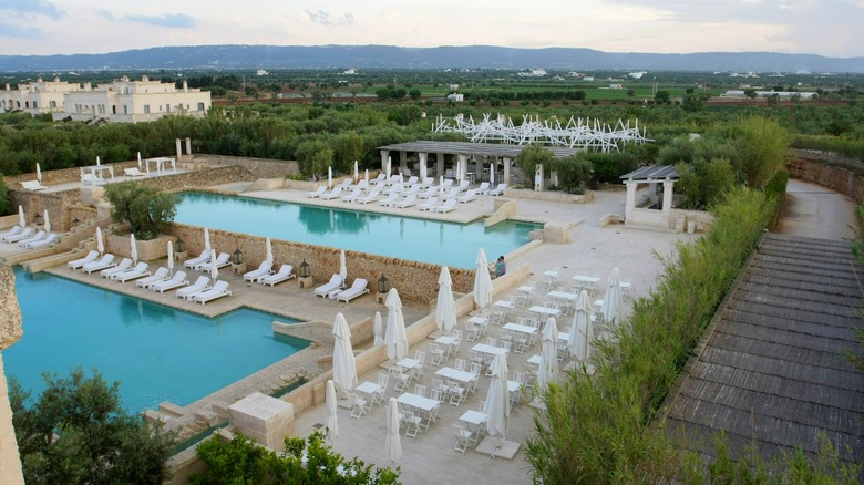 two pools surrounded by white sun loungers at Borgo Egnazia in Puglia, Italy