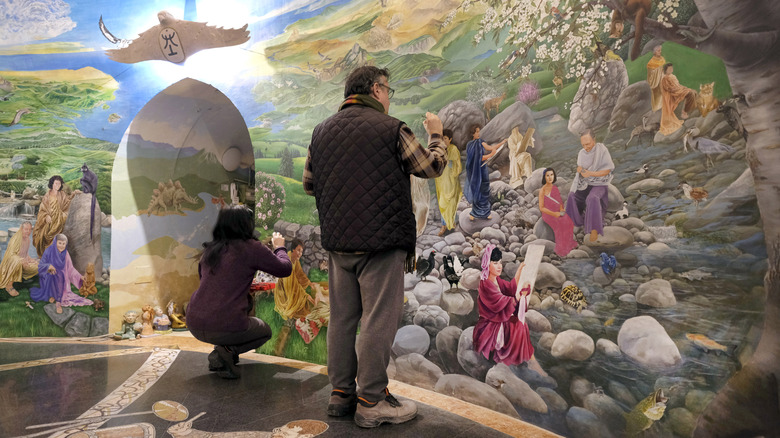 Tourists taking pictures of the walls in the Temples of Humankind in Italy