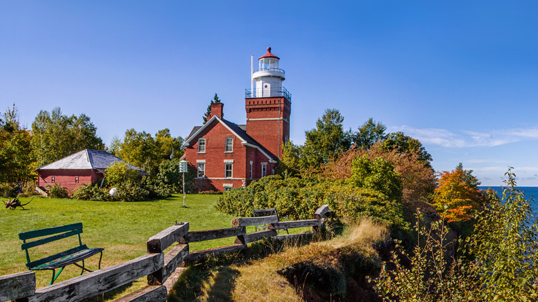 A fence in front of the Big Bay Point Lighthouse on an autumn day