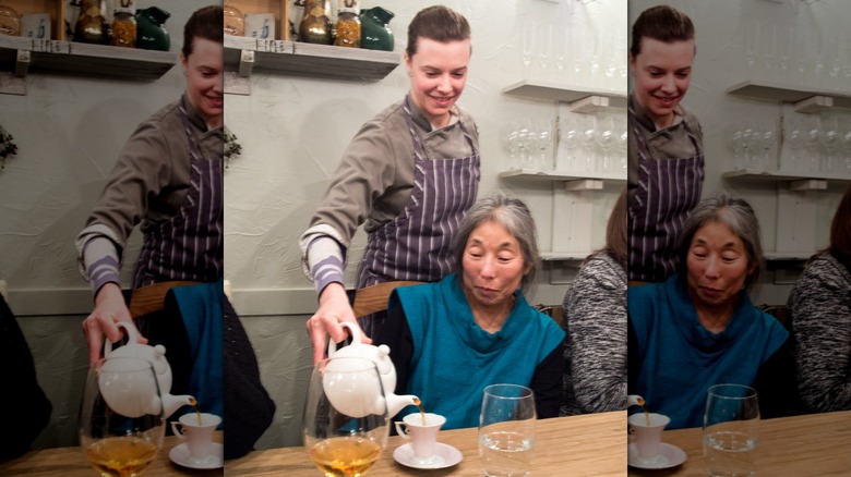 Chef Lane Regan pouring tea for a guest at their restaurant