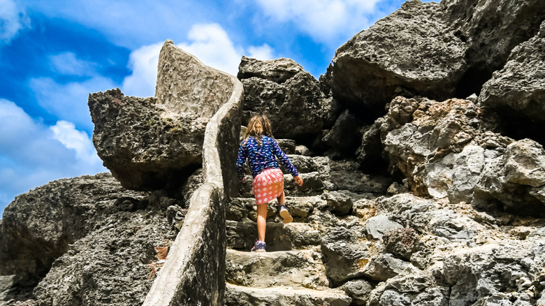 Girl climbing up stone staircase at Shete Boka National Park