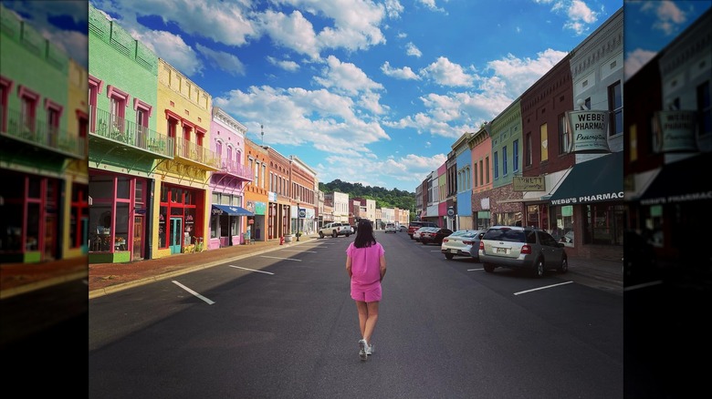 Woman standing looking at colorful buildings of Yazoo City Main Street